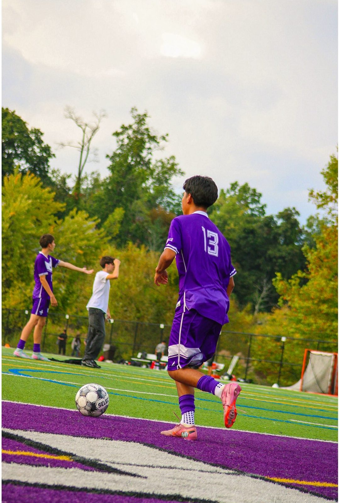 Player 13 carrying the ball along the sideline